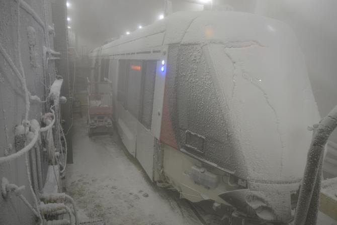 Passenger rail vehicle covered in ice/snow in large chamber
