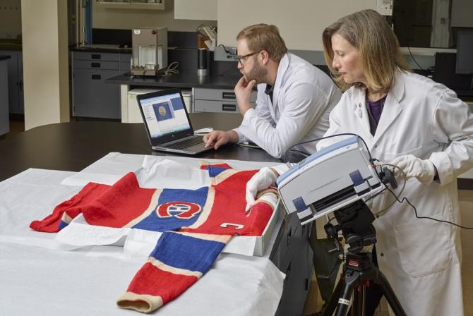 Deux scientifiques utilisent un équipement pour effectuer des analyses sur un chandail de hockey des Canadiens de Montréal