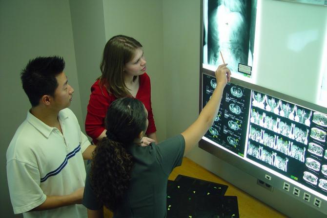 Trois personnes examinent une radiographie