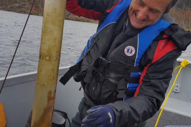 Un chercheur à bord d’un bateau emploie un piège à sédiments en suspension