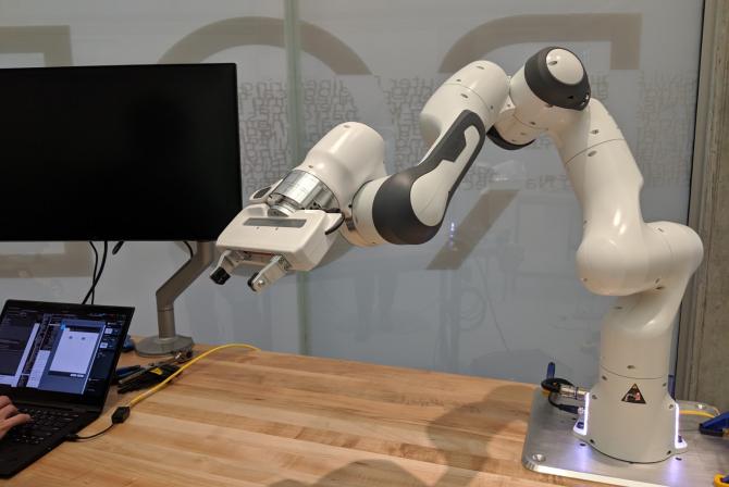 Panda robot arm next to a workstation