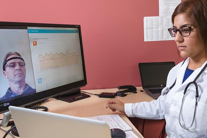 Chercheur qui teste un logiciel interactif affichant des données à distance sur le patient
