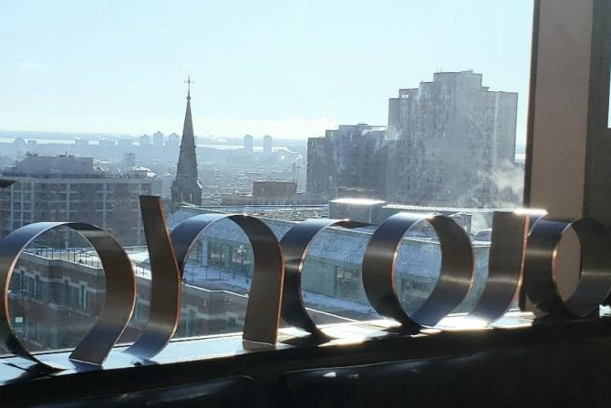 The word "Concordia" on a windowsill with a city view backdrop.