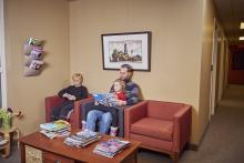 Un homme et deux enfants assis dans une salle d’attente